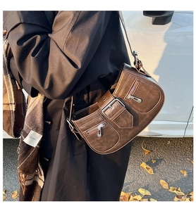 Detail der dunkelbraunen Retro-Schultertasche mit Metallschnalle und Reißverschluss