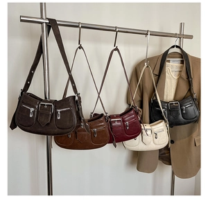 Detail shot of vintage style baguette bags in five colors hanging on a metal display stand