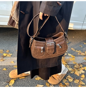 Detail der braunen Vintage-Schultertasche mit Metallschnalle und matter Ledertextur