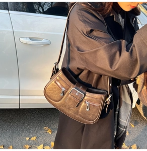 Detail der dunkelbraunen Vintage-Umhängetasche mit Retro-Schnallen und Reißverschlüssen