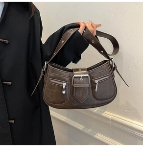 Detail der braunen Vintage-Tasche mit Silberschnalle und Schultergurt mit Metallösen