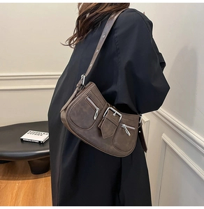 Detail of dark brown vintage leather shoulder bag with silver buckle and zippers