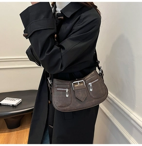 Details der dunkelbraunen Vintage-Ledertasche mit Metallschnallen und Reißverschlüssen