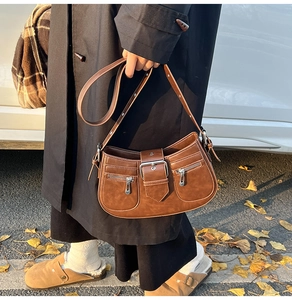 Detailansicht der braunen Vintage-Achseltasche mit Metallschnalle und Reißverschlüssen