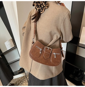 Braune Vintage-Schultertasche mit Doppelreißverschluss und Schnalle am Modell getragen