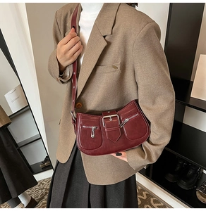 Details der burgunderroten Ledertasche mit silbernen Schnallen und seitlichen Reißverschlüssen