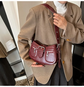 Detailansicht der weinroten Kunstledertasche mit Zierschnallen und Reißverschlüssen