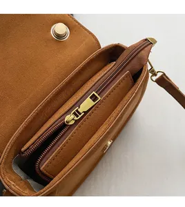 Internal view of brown suede crossbody bag showing smooth zipper pocket and gold hardware