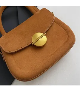 Detailed view of brown suede material texture and premium gold round metallic buckle