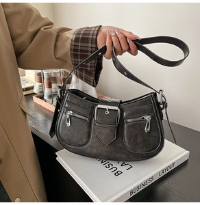 Detailansicht der grauen Vintage-Achseltasche mit Reißverschlusstaschen und Metallschnallen