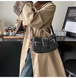Detail einer schwarzen Vintage-Schultertasche mit doppelten Reißverschlüssen und Zierschnalle