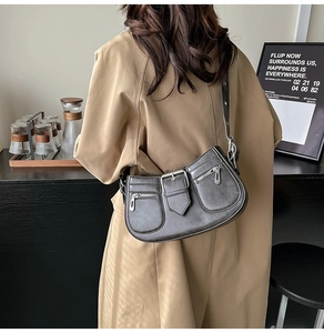 Detail of dark grey retro saddle bag with Y2K biker style zippers and belt buckles