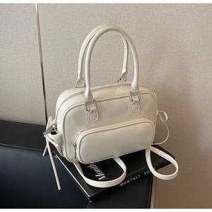 Detail of cream white retro bowling bag with side bow decor and front zipper pocket