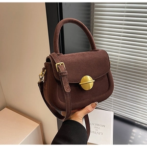 Brown suede saddle bag detail with golden round buckle and detachable leather strap