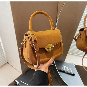 Handheld brown frosted leather crossbody bag featuring a round golden metal buckle detail