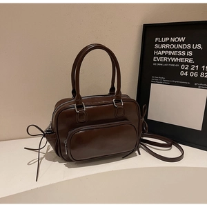 Primer plano de bolso vintage marrón con cremalleras y detalles de cordón ajustable