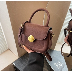 Brown suede handbag featuring gold round buckle with crossbody strap and handle