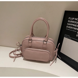 Detalle del bolso rosa con cordones laterales y bolsillo frontal con cremallera