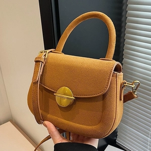 Brown suede handbag featuring a round gold metal buckle with adjustable shoulder strap