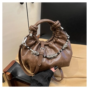 Detail of soft pleated cloud bag in coffee brown with decorative beaded metal chain