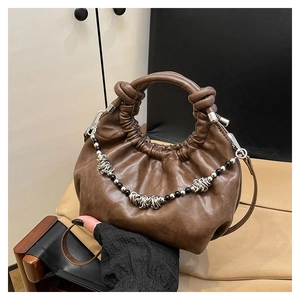 Detail of dark brown ruched handbag featuring knotted handle and decorative beaded chain