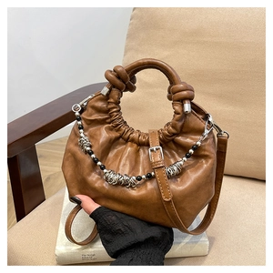 Detail of brown pleated leather cloud bag with silver hardware and beaded chain decoration