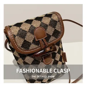 Detail shot of checkered texture with leather trim and decorative horn-shaped buckle closure