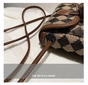 Close-up of checkerboard pattern shoulder bag with brown leather trim and contrast stitching