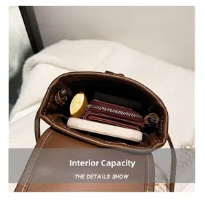 Detail showing internal capacity of the brown PU leather mini crossbody bag with phone space