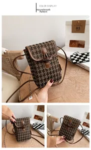 Detailed macro view of houndstooth mini crossbody bag with brown leather and horn buckle