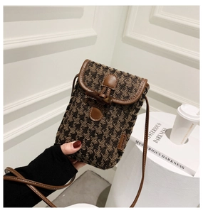 Close-up of checkered mini crossbody bag with leather trim and vintage horn buckle