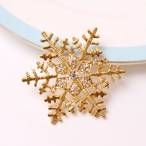 Close-up of a gold snowflake napkin ring with crystals on a white ceramic plate