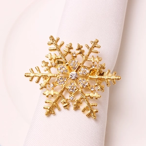 Golden snowflake napkin ring with clear rhinestones on white fabric napkin display