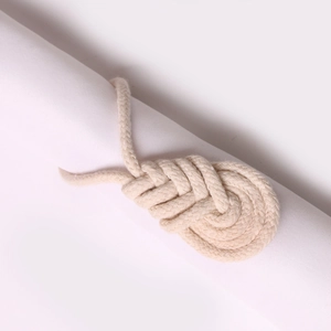 Nahaufnahme eines handgefertigten Serviettenrings aus Jute mit minimalistischem Knotendesign