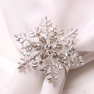 Macro shot of silver snowflake napkin ring with rhinestones on white knit fabric