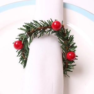 Close-up of handmade Christmas napkin ring with red berries and green pine needles
