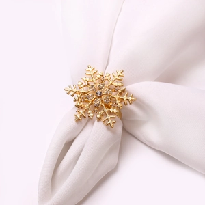 Macro detail of golden snowflake napkin ring with rhinestones on white napkin