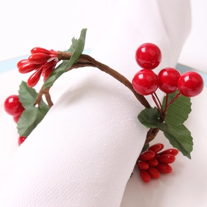 Festive Christmas napkin ring with red berries and green leaves on brown vine base