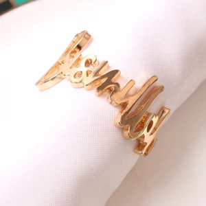 Servilletero de metal dorado pulido con diseño de palabra Family sobre tela blanca