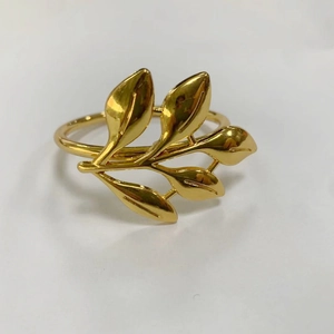 Detalle de servilletero de hoja de oro mate con rama y cinco hojas metálicas realistas
