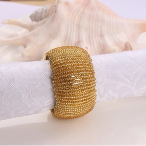 Elegant gold beaded napkin ring with a wide woven design for luxury table decoration
