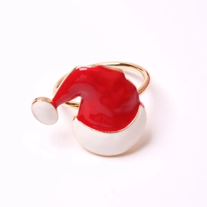 Golden napkin ring featuring a red and white enamel Santa hat design on white background
