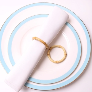 Natural round bamboo napkin rings set of two on white fabric and ceramic plate