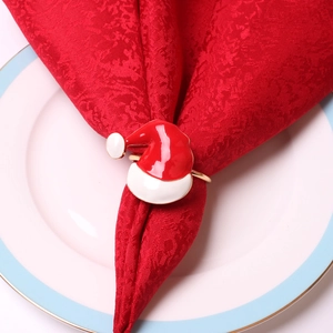 Christmas Santa hat napkin ring with red enamel finish on festive dining table setting