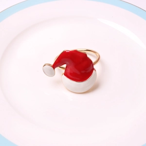 Detail of red Santa hat napkin ring with gold buckle on a white ceramic plate
