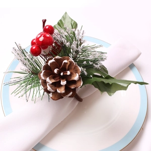Detalle de un servilletero navideño con piña de pino y bayas rojas festivas