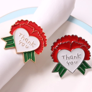 Close-up of festive red enamel flower napkin rings with heart-shaped Thank You engraving