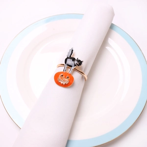 Detail of Halloween napkin ring with black cat and orange pumpkin on a white napkin
