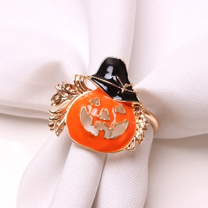 Macro detail of Halloween pumpkin napkin ring with wizard hat on white fabric