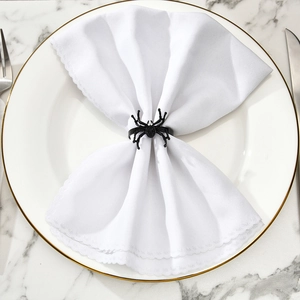 Elegant black spider napkin ring with crystals on white napkin and marble table